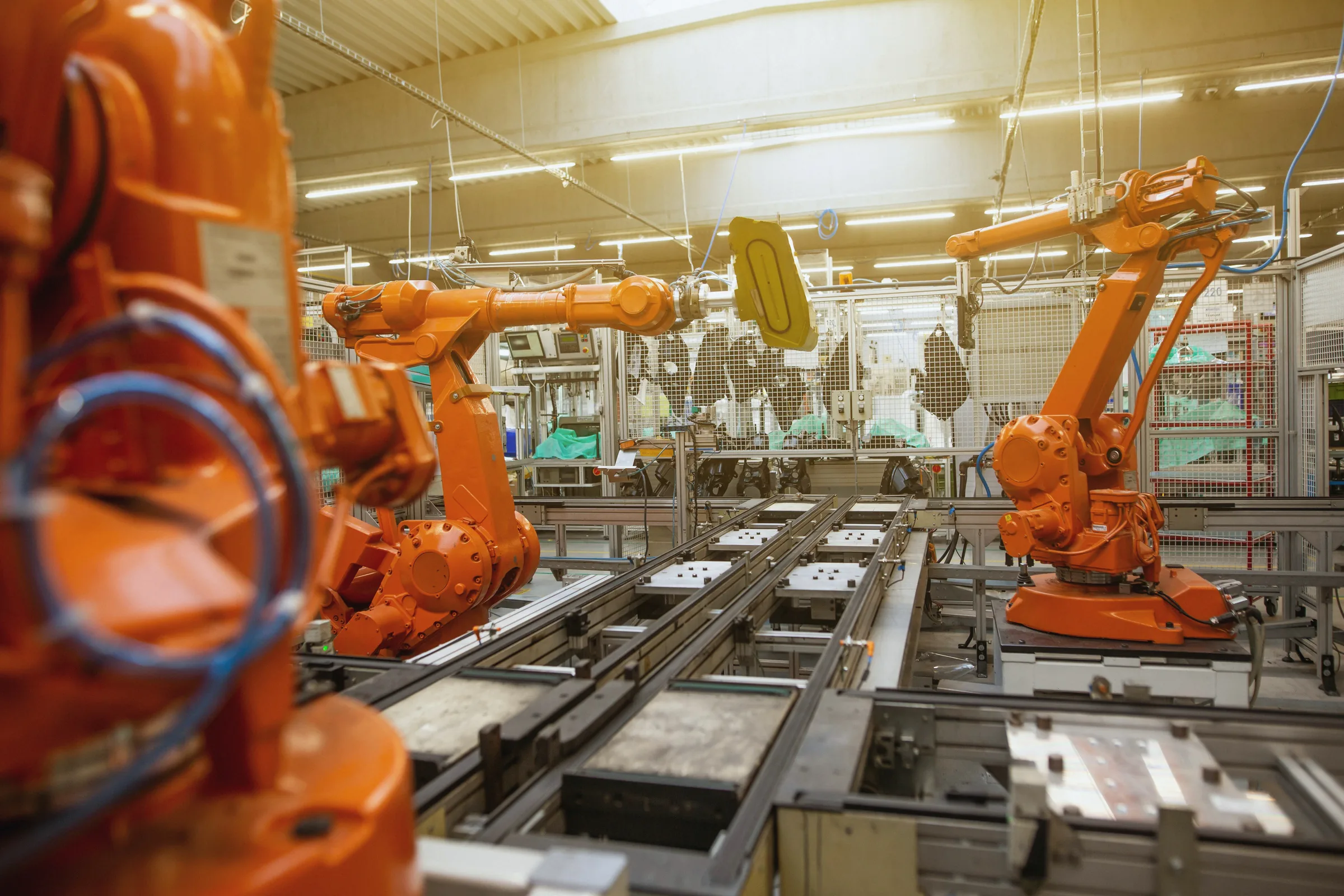 Bir üretim hattında turuncu endüstriyel robot kolları